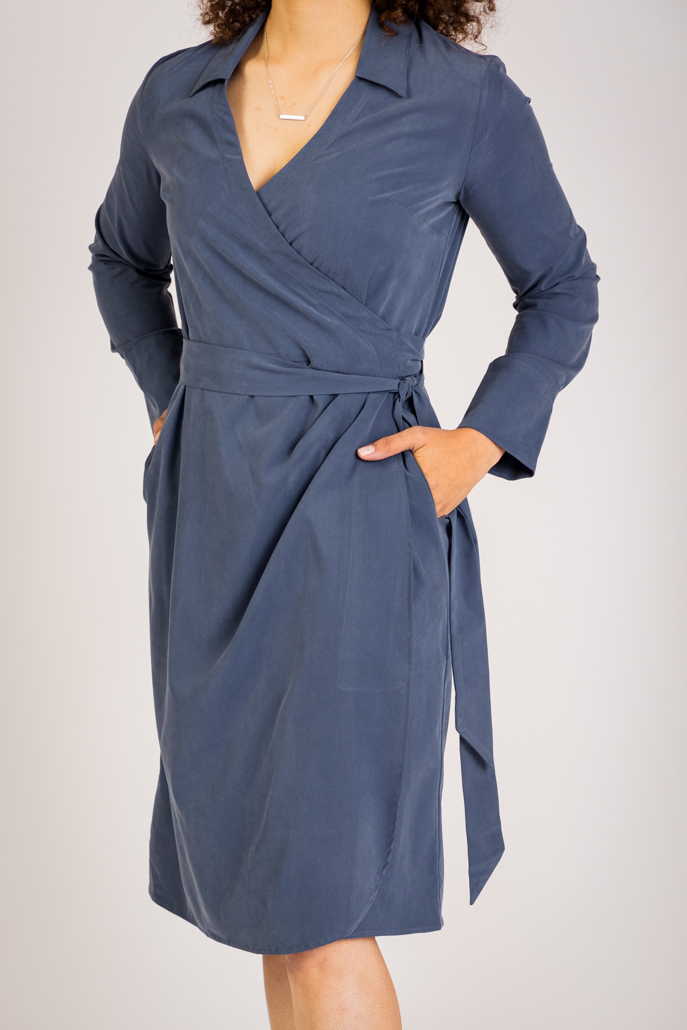 The Trinity Wrap Dress offers a flattering, slim-fit silhouette perfect for professional outfits. Its tailored shape and adaptable sleeve length make it ideal for women’s corporate wear, while convenient pockets add functionality for work wear needs.